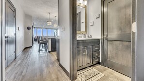 A modern kitchen with dark wood cabinets, a large island, and pendant lighting.