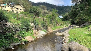 Un río serpentea por un valle con paredes de piedra y vegetación en sus orillas.