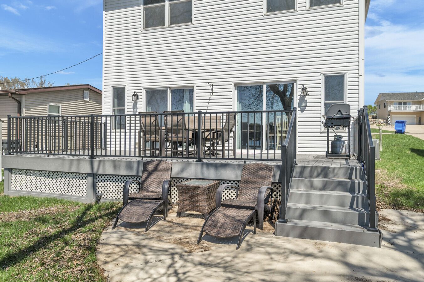A residential deck with outdoor furniture and a barbecue grill.