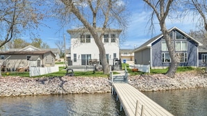 A waterfront property with a dock, a white house with a tower, and a blue house.