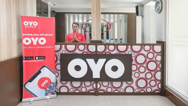 A reception area with a large OYO Hotels sign, a digital screen, and a pillar with a circular design. - Hotel O near Jogja Expo Center formerly Hotel Desa Puri (Baturetno)