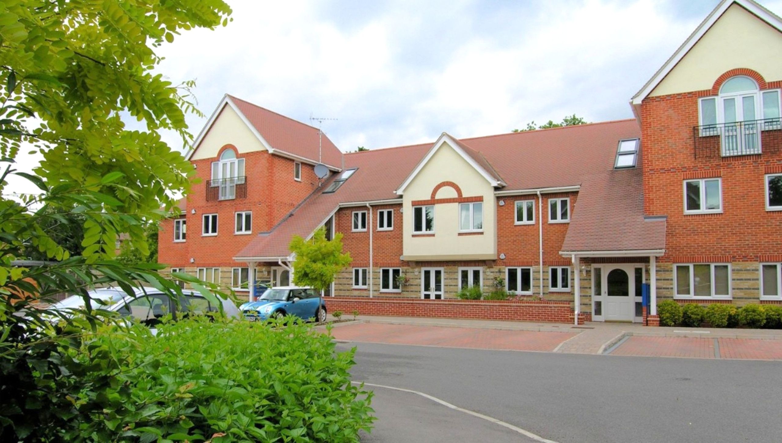A row of brick houses with pitched roofs and satellite dishes.