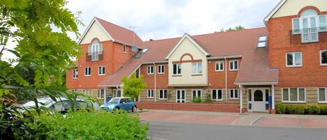 A row of brick houses with pitched roofs and satellite dishes.