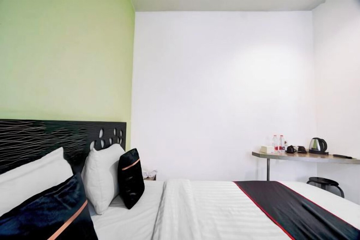 Una habitación de hotel con una cama, un escritorio y una silla.