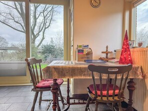 Enjoy meals for two in this inviting dining area with a table, chair, and window offering a view of the outdoors.