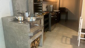 A kitchen with a built-in wood stove, a gas stove, and a coffee machine.