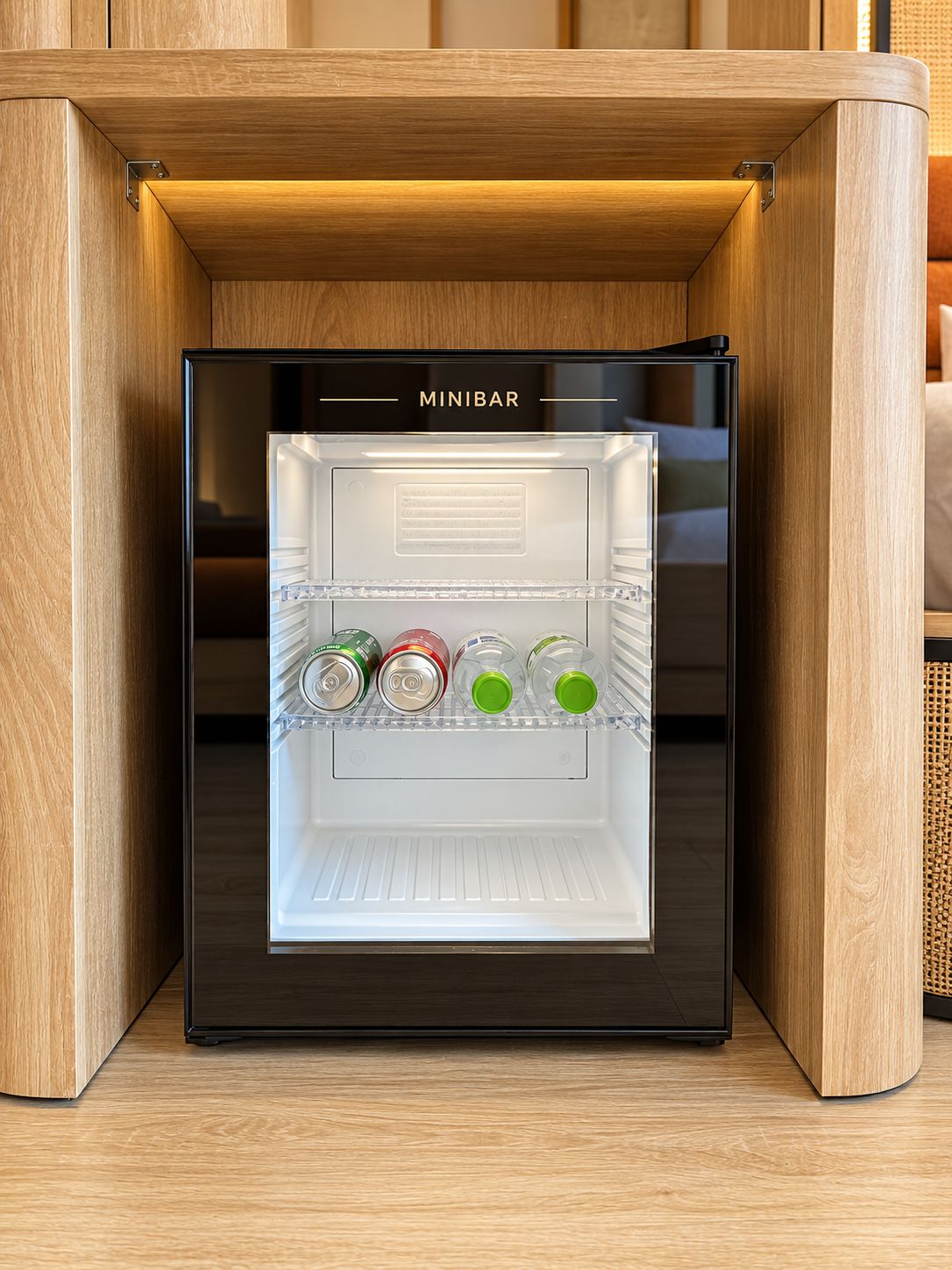 A black mini-fridge with the brand name 'MINIBAR' on the top, containing several beverage bottles and cans.
