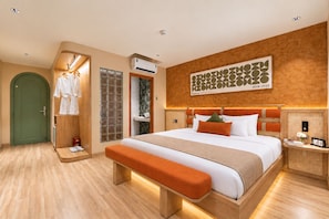 A hotel room with a large bed, a wooden bench, a green door, and a wall-mounted air conditioning unit. - KOVA Hotel - Bui Vien Central (Ho Chi Minh City)