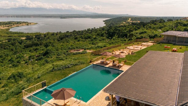 A swimming pool with a view of a lake and mountains in the background. - Acacia Wilderness Mweya (Mweya)