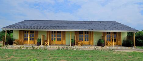 A two-story building with a flat roof and a covered porch.