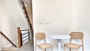A staircase with wooden railings and a white wall with two electrical outlets. - Linshouse (Tainan)