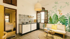 A compact living space with a kitchenette, a dining area, and a sofa. - Eden Westlake Hotel (Hanoi)