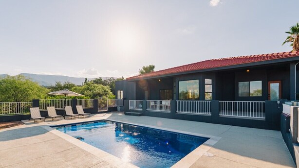 Une piscine extérieure moderne offrant une vue dégagée sur les montagnes en arrière-plan.
