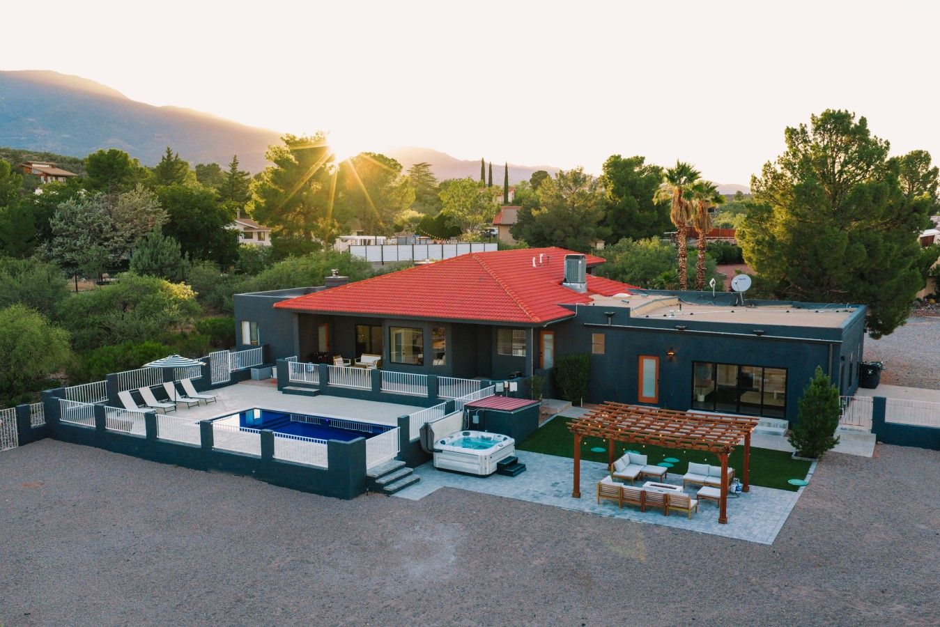 A modern house with a swimming pool, outdoor seating, and a pergola.