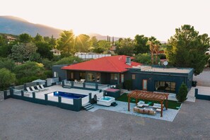 A modern house with a swimming pool, outdoor seating, and a pergola. - Cottonwood Paradise: Luxe Home w/ Pool-Nice Views! (Cottonwood)