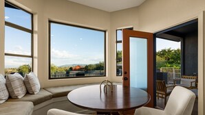 Une pièce dotée d’une table ronde, de sièges et de grandes fenêtres donnant sur l’extérieur.