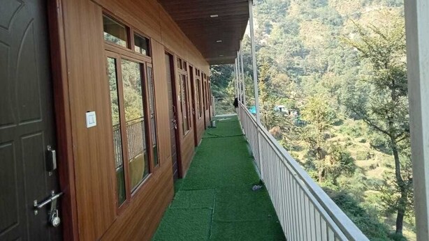 Un edificio de madera con un balcón que da a un paisaje montañoso.