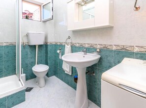 A bathroom with a toilet, sink, and bathtub. - Relaxing Apartment on Budva Coastline (Budva)