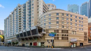 A multi-story hotel with a curved facade, multiple balconies, and a prominent entrance. - Bright & Spacious 1-Bed in Vibrant Sydney (Sydney)