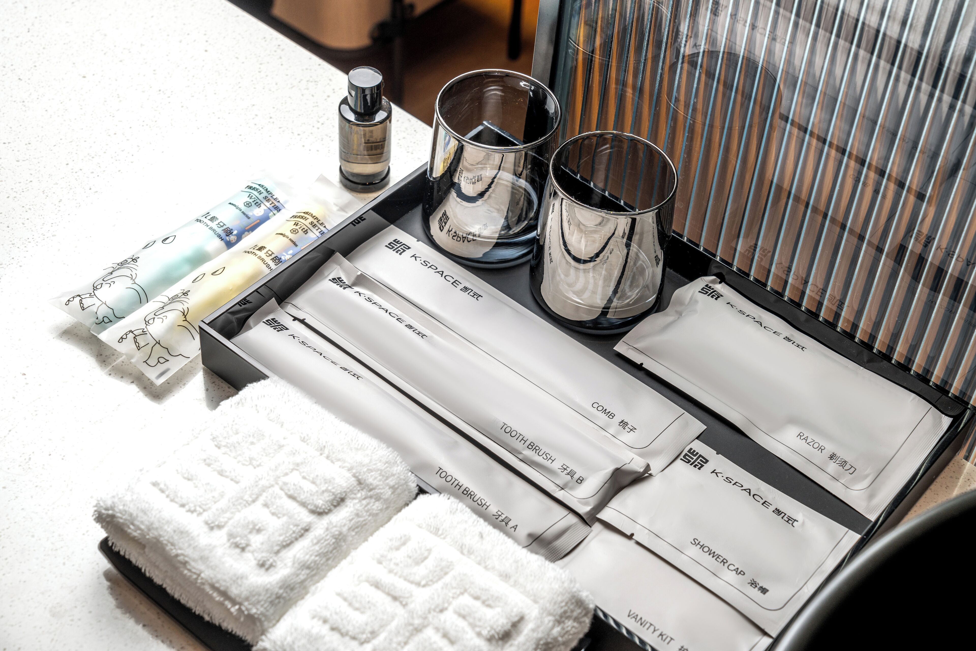 Ett välordnat badrum med toalettartiklar, en handduk och en duschmössa.