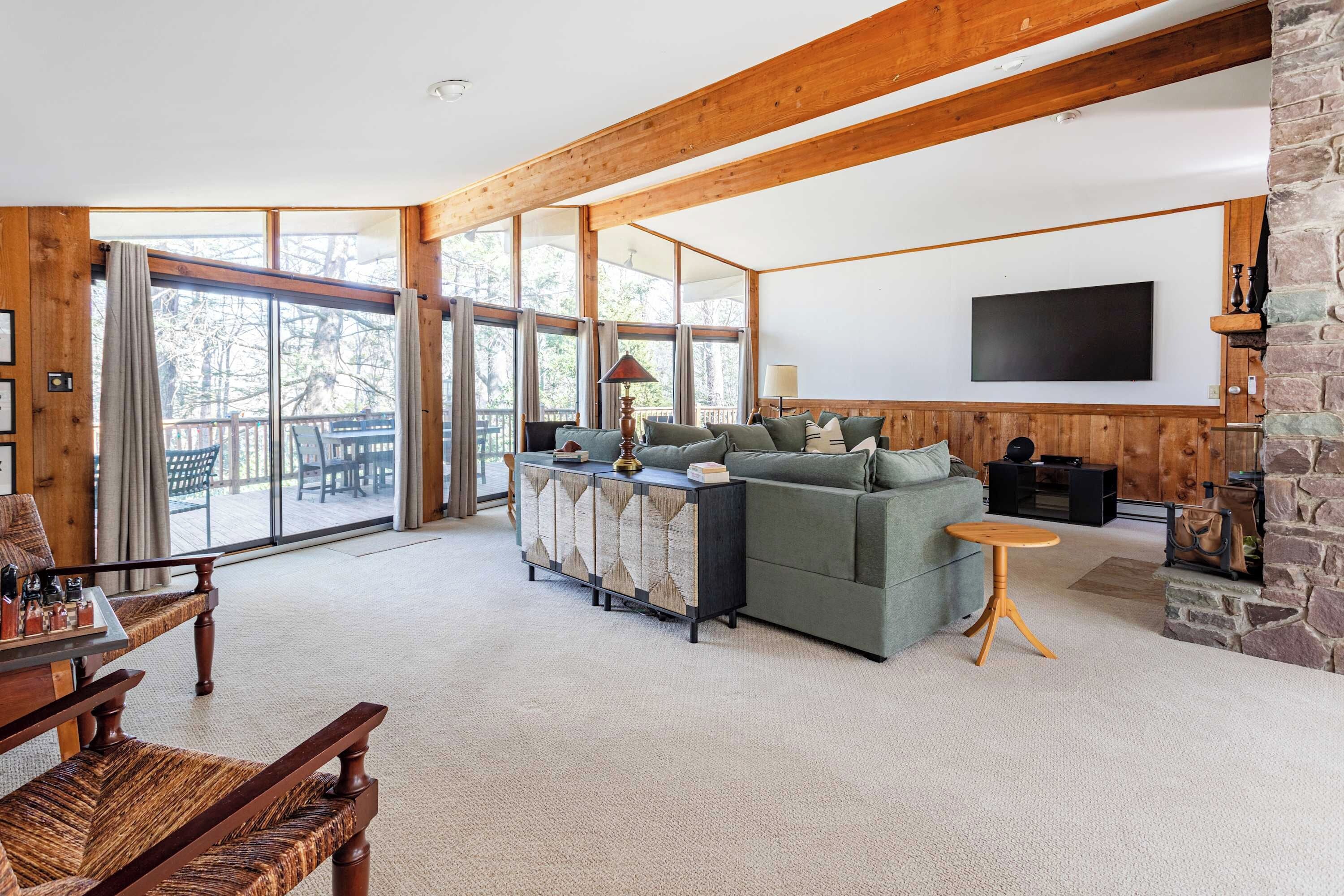 Un salon spacieux avec un grand canapé, une table basse en bois et une cheminée en pierre.