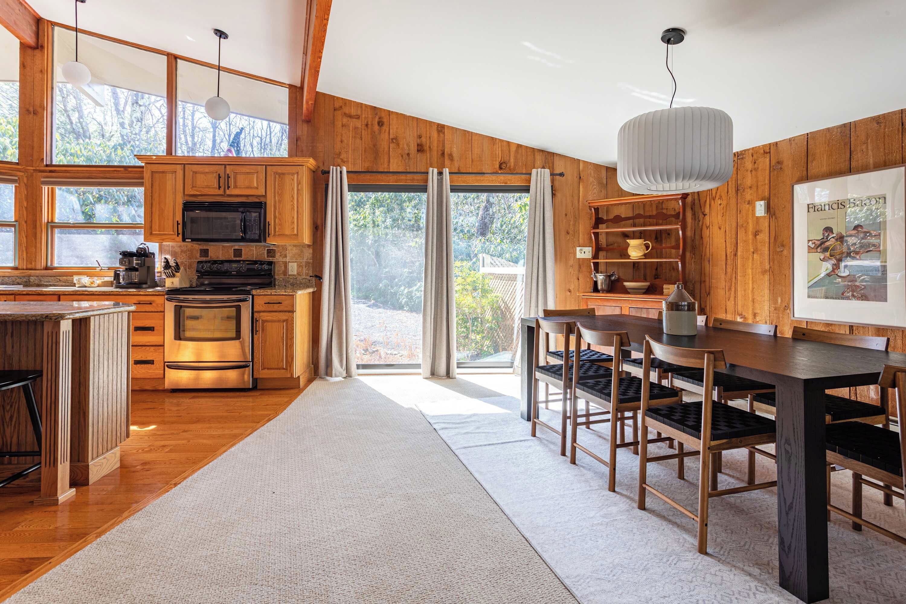 Una cocina amplia con armarios de madera, una isla grande y un comedor con mesa y sillas.