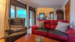 A living room with a red sofa, a grey armchair, and a wooden coffee table.