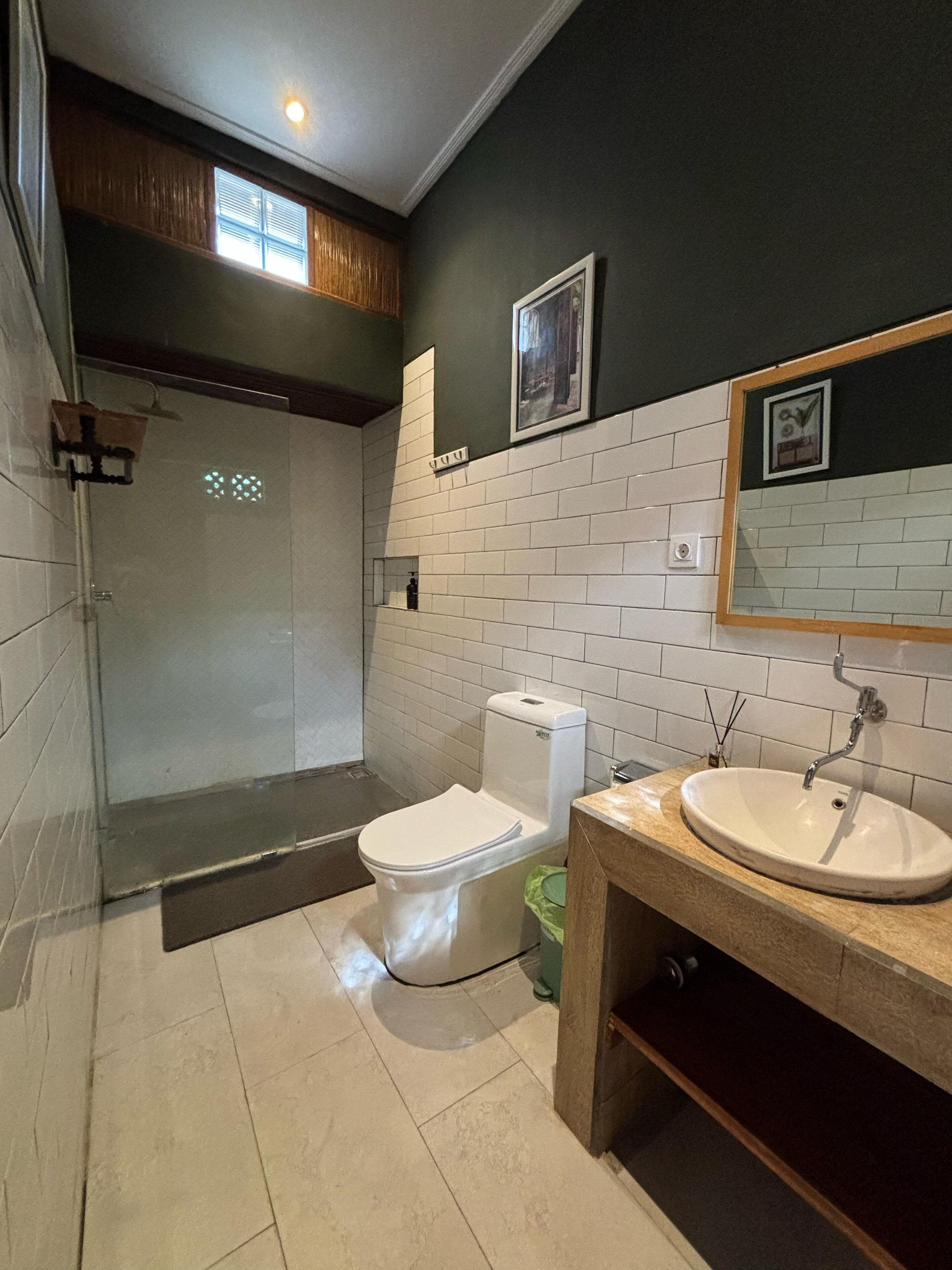 A bathroom with a toilet, sink, and shower.