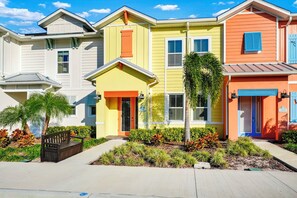 A row of colorful houses with a small garden in front.