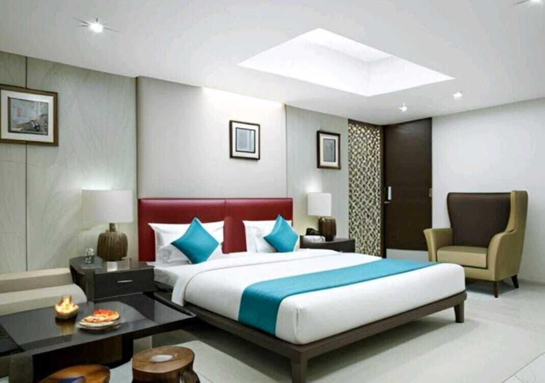 Een hotelkamer met een groot bed, een bureau, een stoel en een nachtkastje.