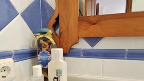 A bathroom counter with toiletries including a bottle of Aveeno moisturizer, a bottle of Q+S Power Gel, and a scented bath product. - Rezon 4 5580 in Conil de la Frontera (Conil de la Frontera)