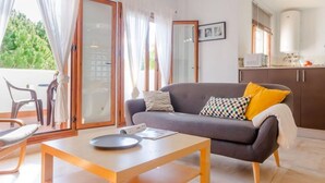 A living room with a sofa, a small table, and a view of the outdoors.