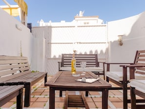 Enjoy dining or socializing in this outdoor patio area with a table for two and comfortable seating.