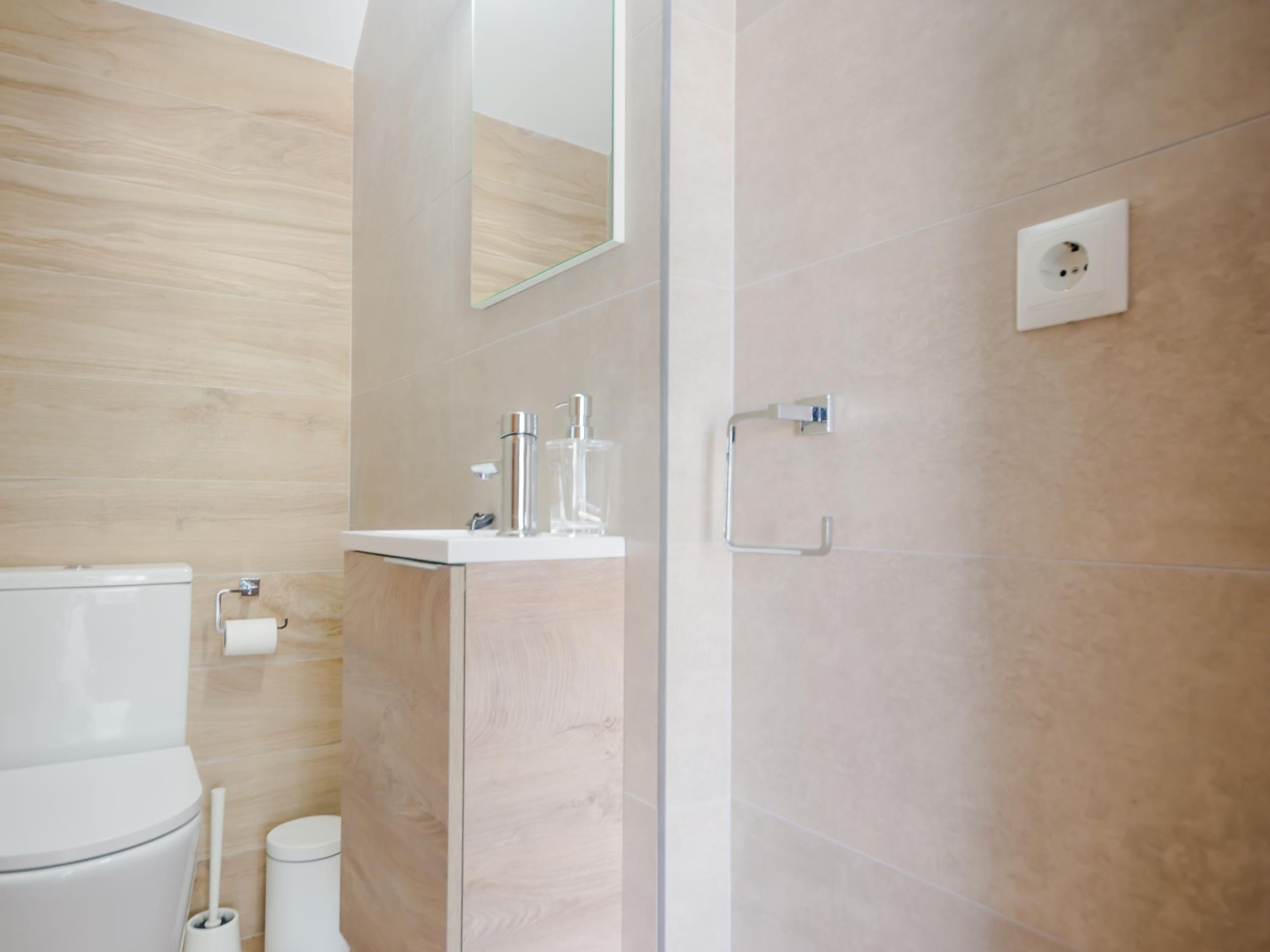 Une salle de bain moderne équipée de toilettes, d’un lavabo et d’une zone douche.