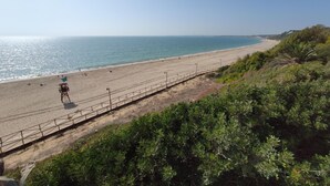 A beach with a lifeguard tower, a fence, and greenery. - Bah a Blanca II 18923 (El Puerto de Santa Maria)