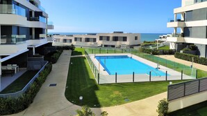 Ein moderner Apartmentkomplex mit Schwimmbad und Meerblick.