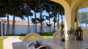 Un espacio de comedor al aire libre con una mesa, sillas y una revista.