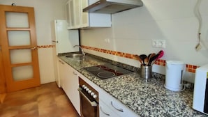 Eine Küche mit einer Granitabdeckung, einer Edelstahlspüle und einem eingebauten Backofen.
