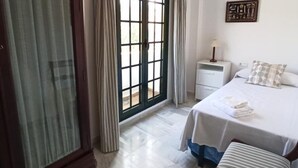 A hotel room with a bed, a nightstand, a lamp, and a window with curtains. - Villa Mar De Las Redes 25903 (El Puerto de Santa Maria)