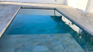 A rectangular swimming pool with clear blue water, surrounded by stone tiles. - Villa El Lagar 14238 (Chiclana de la Frontera)