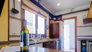 A kitchen with granite countertops, a wine bottle, and a wine glass. - Villa Las Palomas 14988 (Chiclana de la Frontera)