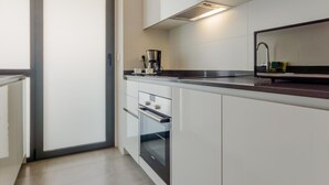 A modern kitchen with white cabinets, a stainless steel range hood, and a coffee maker on the counter. - Bah a Blanca III 18925 (El Puerto de Santa Maria)