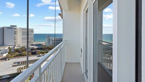 Ein Balkon mit Blick auf das Meer und die Stadtlandschaft, darunter ein Hilton Hotel.