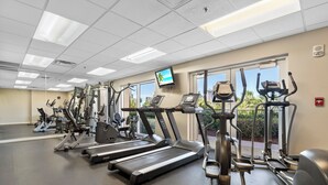 Ein Fitnessstudio mit mehreren Laufbändern, Crosstrainern und Kraftgeräten.