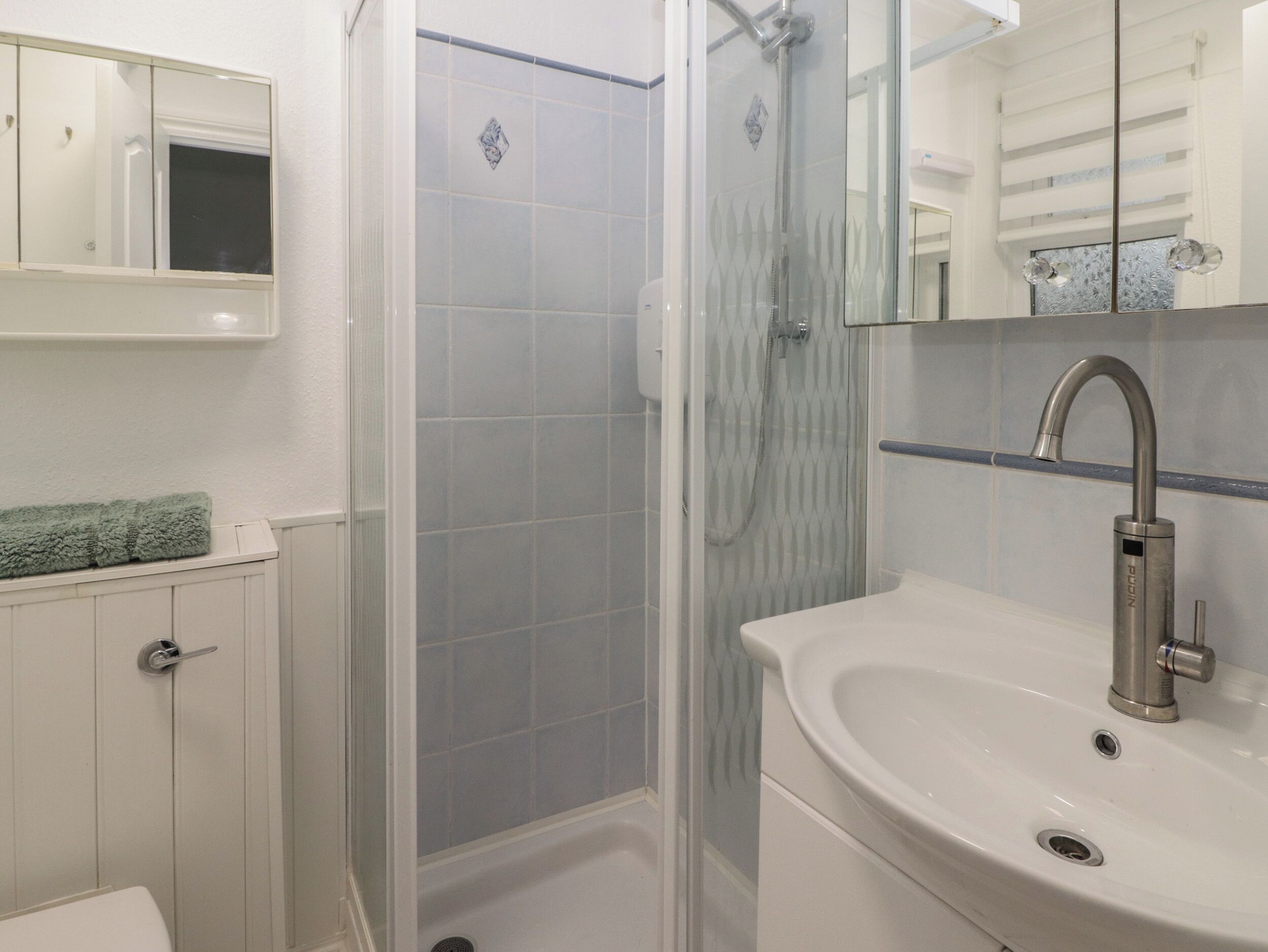 A bathroom with a shower, a sink, and a mirror.