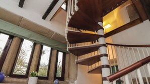 A spiral staircase with a wooden finish and white railings, leading to an upper floor. - Pear Tree Cottage at Hey Farm (Barnoldswick)