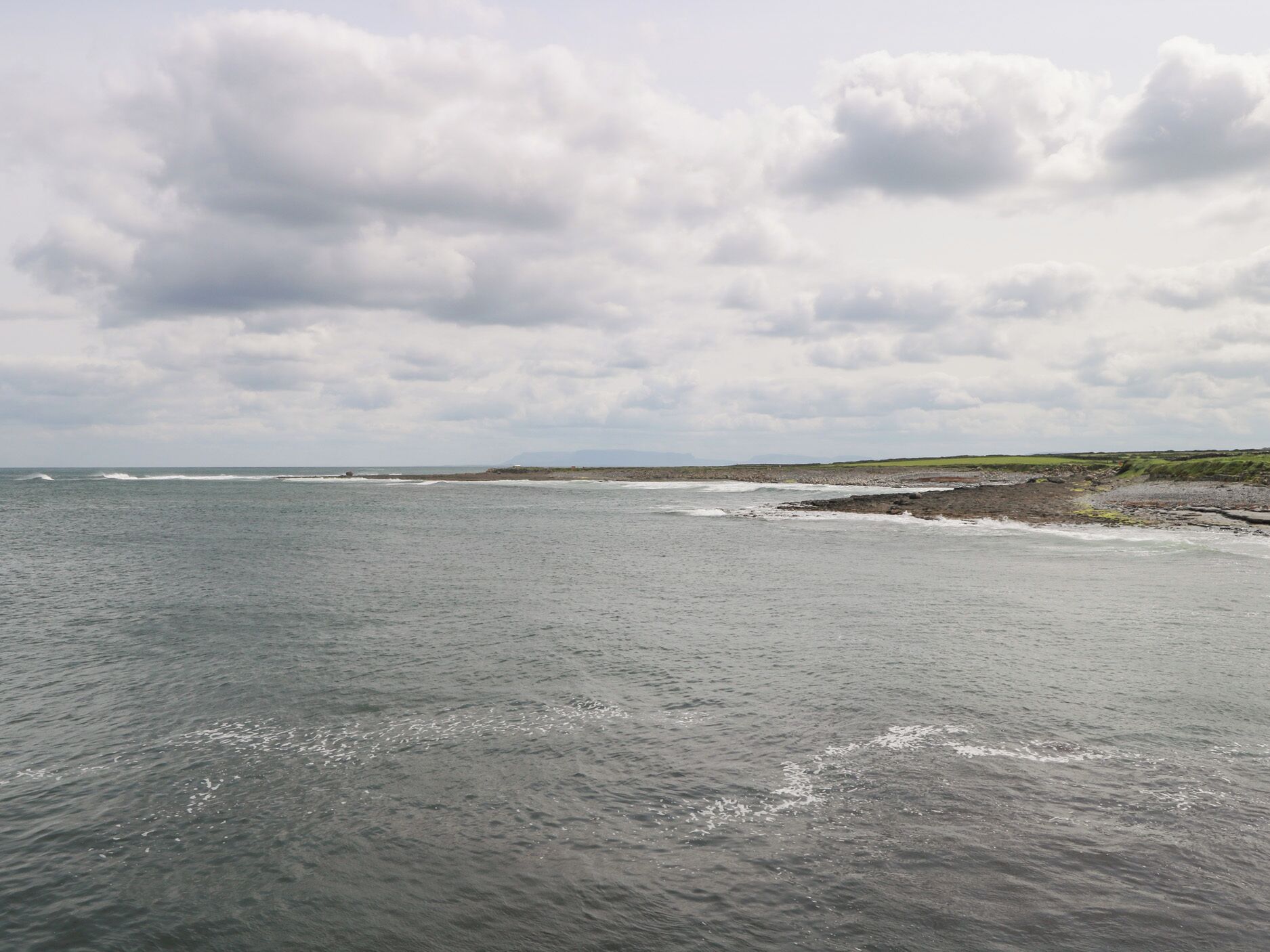 Un paisaje costero con vista al mar y tierra a lo lejos.