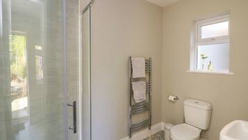 A bathroom with a shower, toilet, and sink.