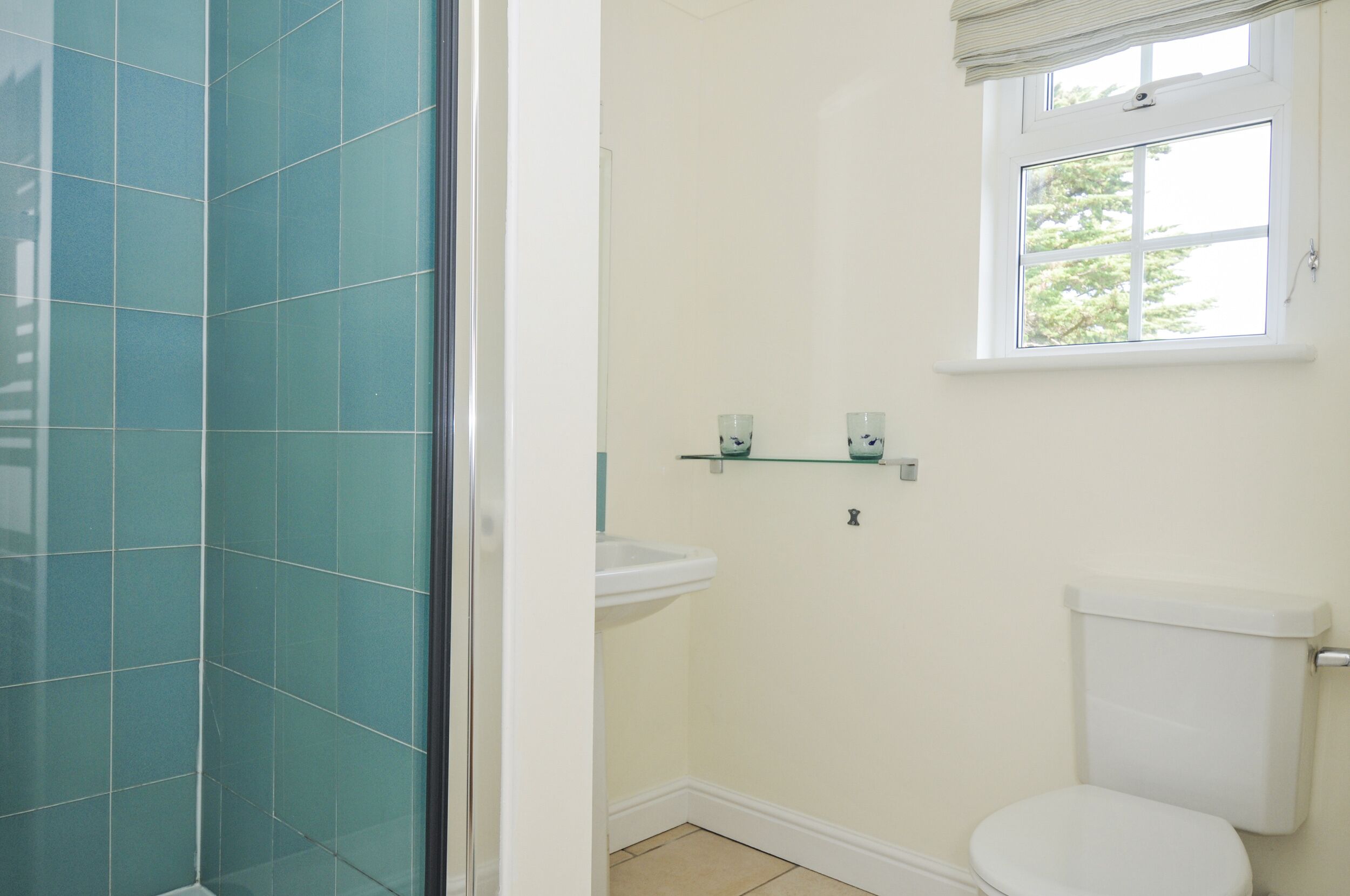A bathroom with a shower, toilet, and sink.