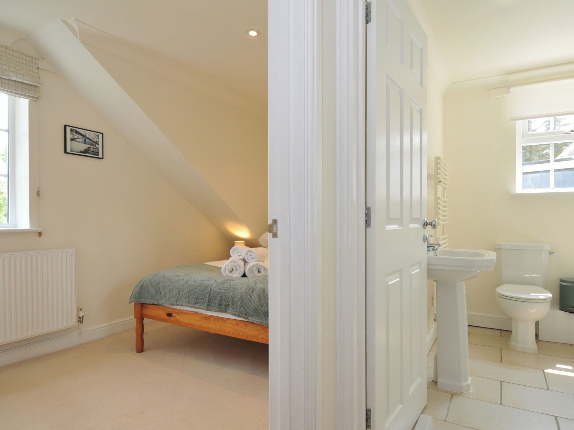 A bedroom with a bed, a bedside lamp, and a window.
